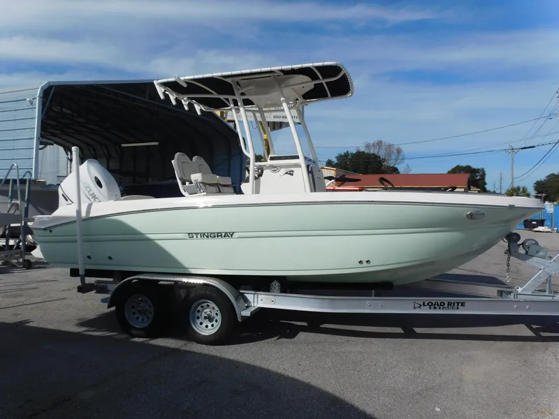 Slide: The Image of 2024 Stingray 216 CC boat on Load Rite trailer in outdoor setting. - 4