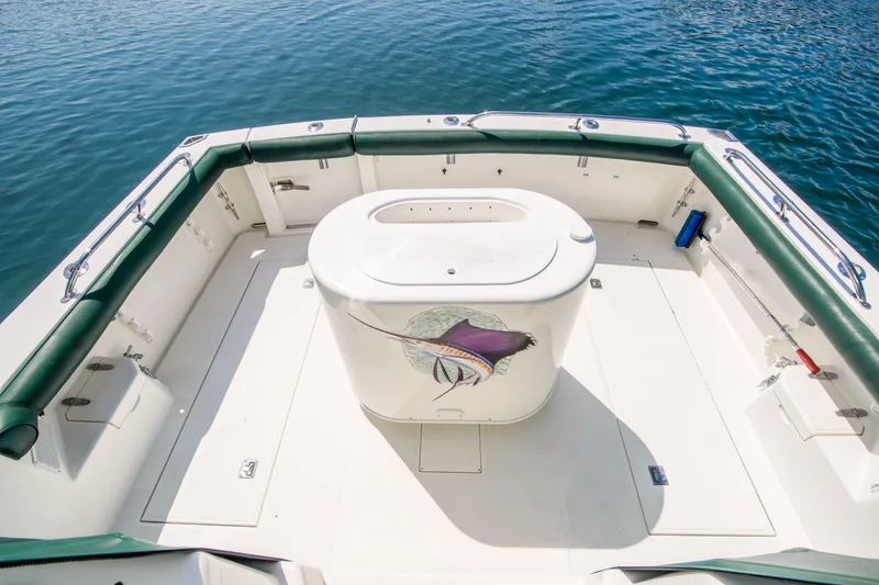 Slide: The Image of 1997 Cabo 35 Express boat deck with central storage, surrounded by calm water. - 10