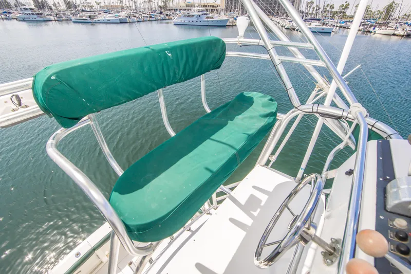 Slide: The Image of 1997 Cabo 35 Express boat helm with green cushioned seating, overlooking marina. - 14