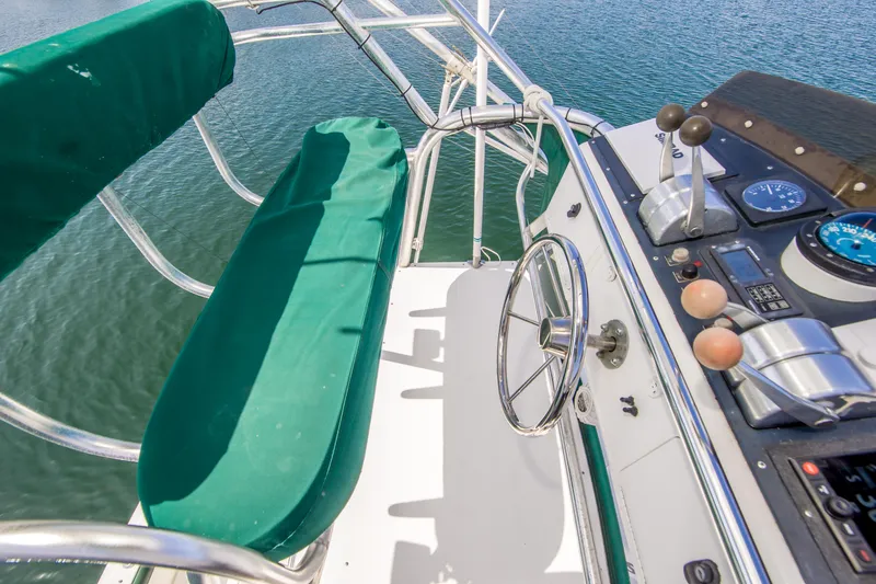 Slide: The Image of Cockpit of 1997 Cabo 35 Express boat with green seating and steering wheel. - 15