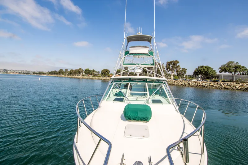 Slide: The Image of 1997 Cabo 35 Express boat on calm water with clear sky and shoreline. - 16