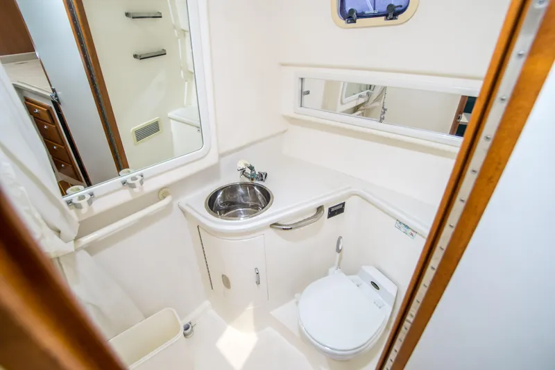 Slide: The Image of 1997 Cabo 35 Express boat bathroom with sink, toilet, and mirror. - 22