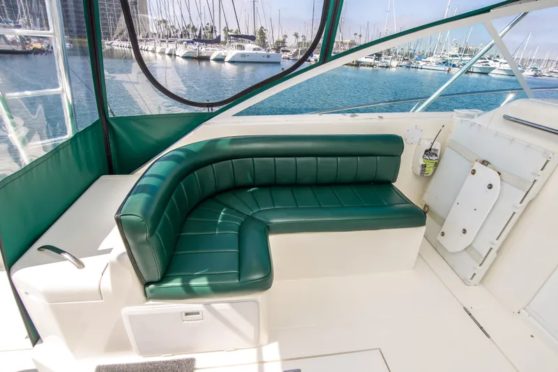 Slide: The Image of 1997 Cabo 35 Express boat with green seating, docked at marina. - 8