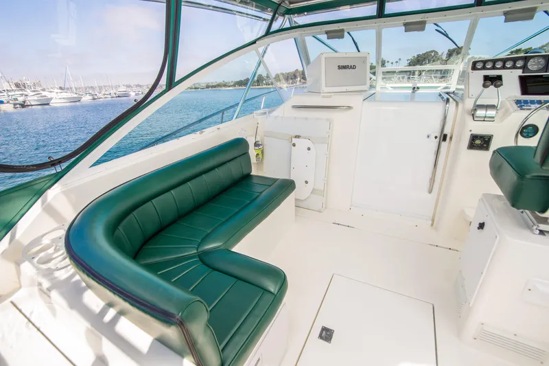 Slide: The Image of 1997 Cabo 35 Express boat interior with green seating, overlooking marina. - 9