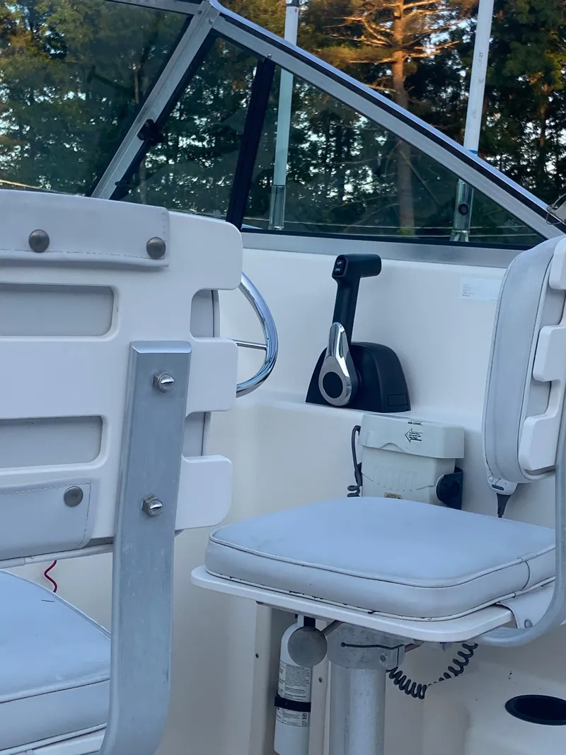 Slide: The Image of 1994 Pursuit 2150 boat interior with white seats and control panel. - 5