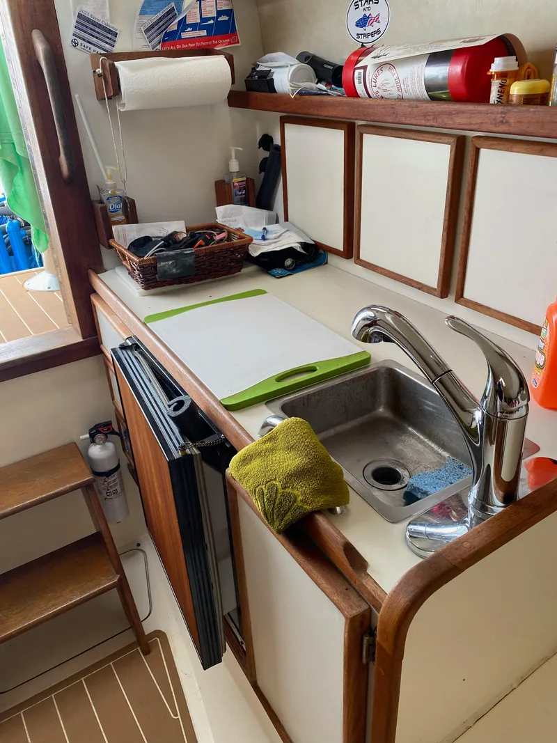 Slide: The Image of 1986 Blackfin 29 Combi boat kitchen with sink, cutting board, and storage cabinets. - 8