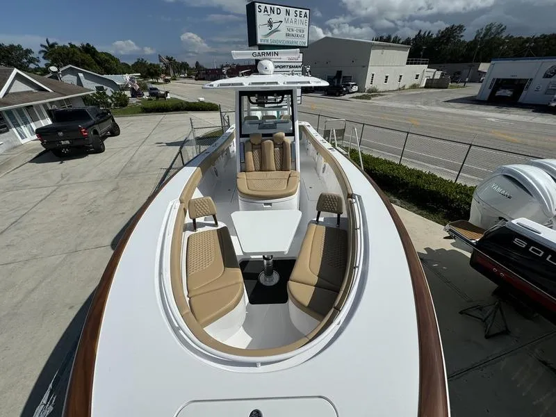 Slide: The Image of 2023 Phenom 34 boat with tan seating and table, docked at Sand N Sea Marine. - 12