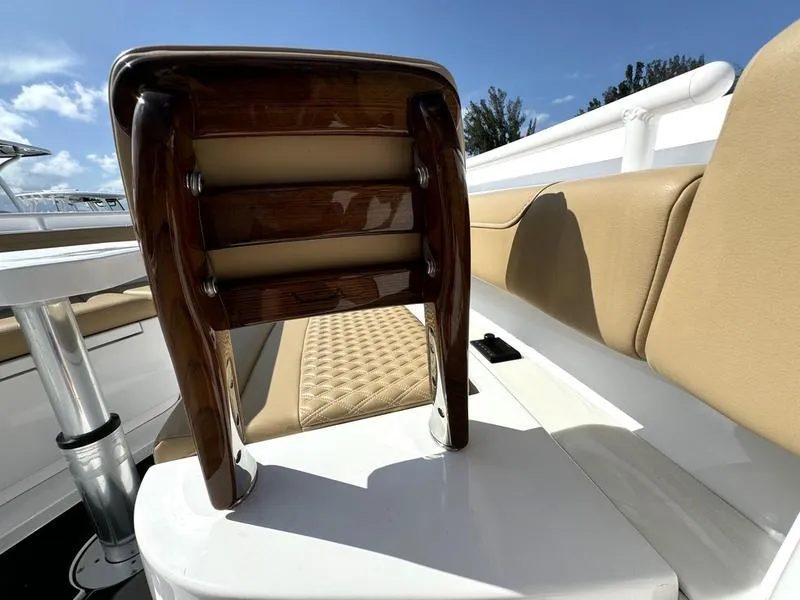 Slide: The Image of Luxury seating on 2023 Phenom 34 boat, featuring tan upholstery and wooden accents. - 18