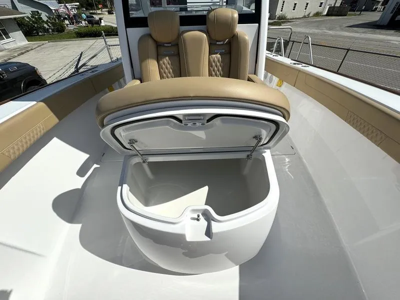 Slide: The Image of 2023 Phenom 34 boat with open storage compartment and tan seating. - 19