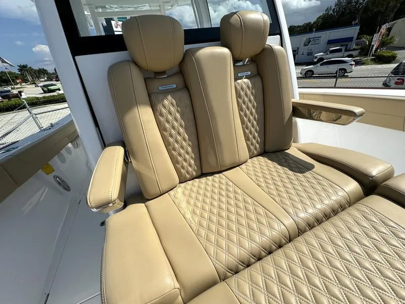 Slide: The Image of Luxurious tan leather seats on a 2023 Phenom 34 boat, featuring diamond stitching. - 20