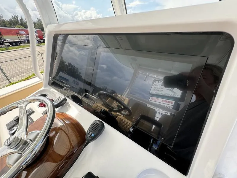 Slide: The Image of Phenom 34 boat dashboard with steering wheel and modern controls, 2023 model. - 34