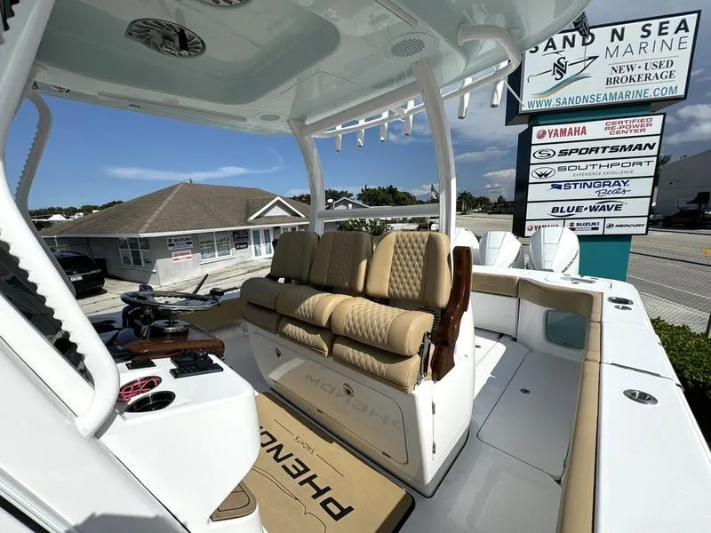 Slide: The Image of Phenom 34 boat interior with tan seating, showcased at Sand N Sea Marine dealership. - 36