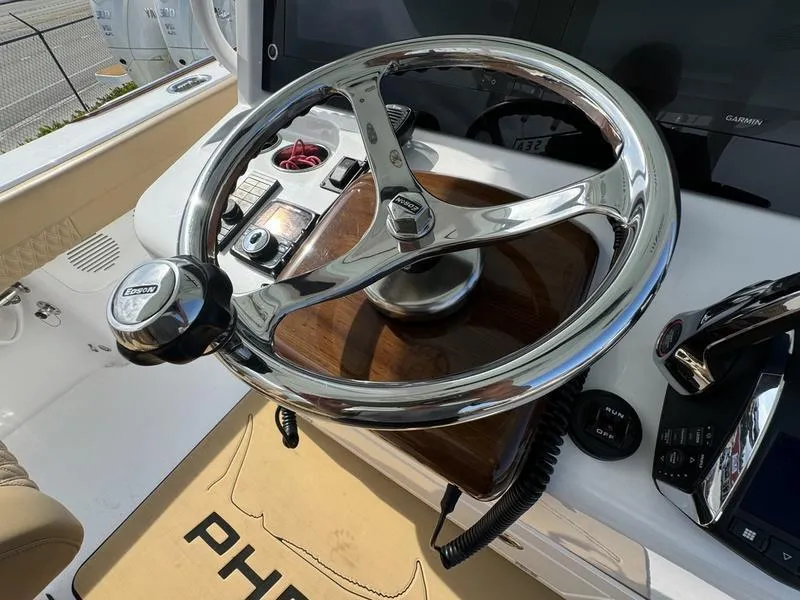 Slide: The Image of Steering wheel of a 2023 Phenom 34 boat, featuring modern controls and sleek design. - 38