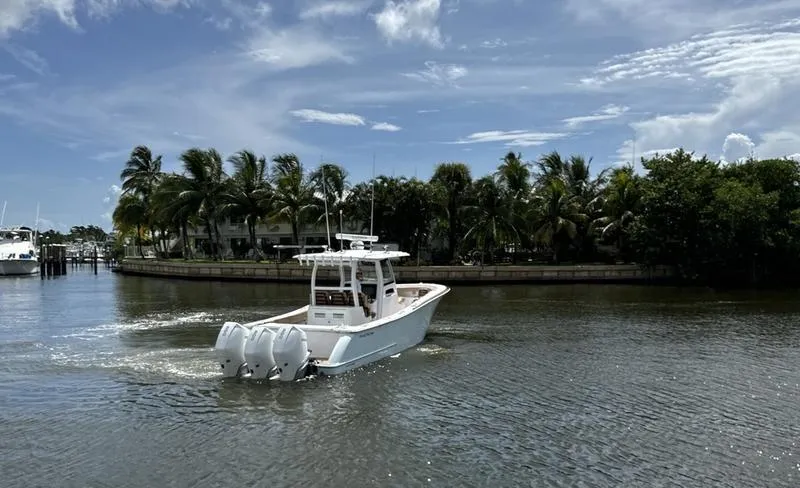 Slide: The Image of Phenom 34 boat cruising on a sunny day, 2023 model, with palm trees in the background. - 4