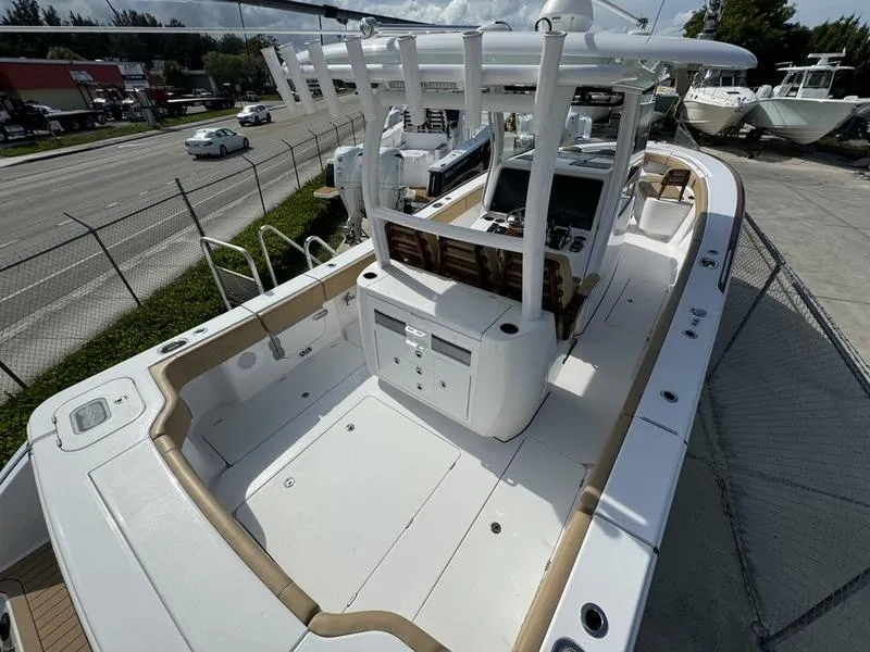 Slide: The Image of 2023 Phenom 34 boat with spacious deck and modern controls, docked near a road. - 43