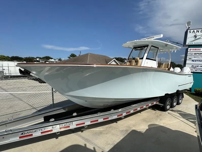 Slide: The Image of 2023 Phenom 34 boat on trailer at dealership under clear sky. - 6