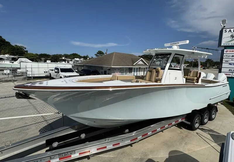 Slide: The Image of 2023 Phenom 34 boat on trailer, displayed outdoors under clear sky. - 7