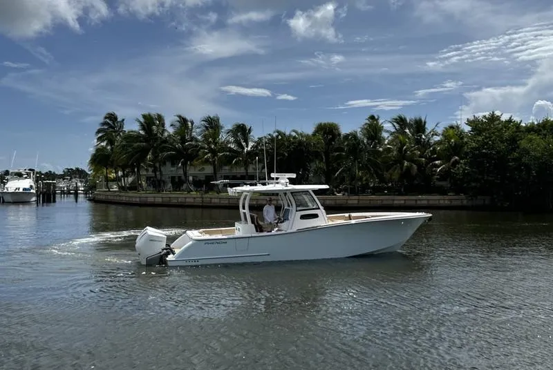 Slide: The Image of 2023 Phenom 34 boat cruising on a sunny day near palm trees. - 8