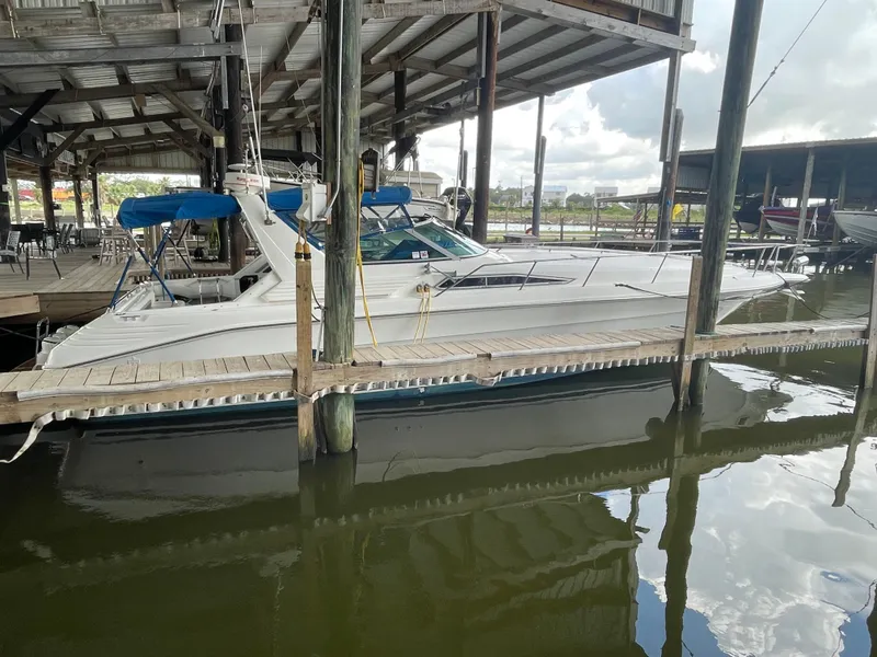 The Image of 1993 Sea Ray 400 Express Cruiser docked in a covered marina. - 0