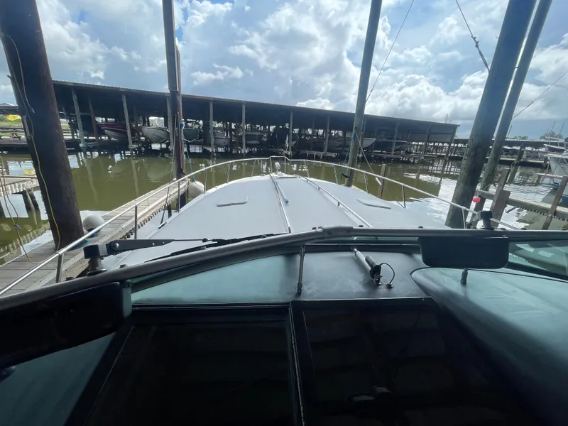 Slide: The Image of 1993 Sea Ray 400 Express Cruiser docked at a marina under a cloudy sky. - 10