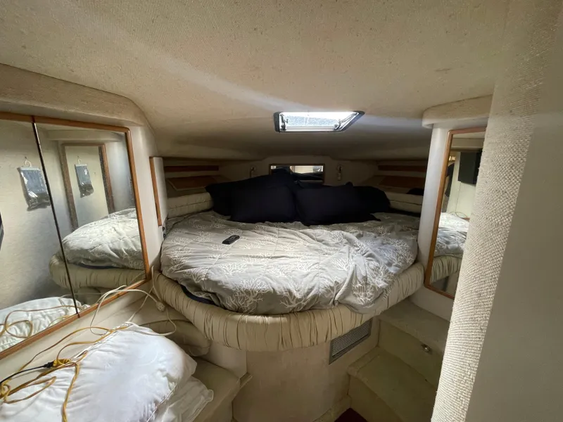 Slide: The Image of 1993 Sea Ray 400 Express Cruiser cabin with bed, mirrors, and skylight. - 13