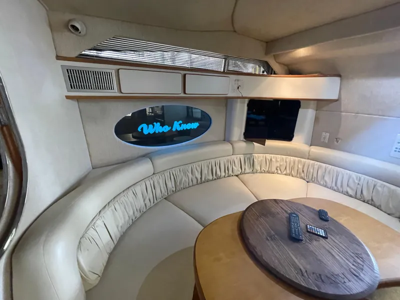 Slide: The Image of Interior of 1993 Sea Ray 400 Express Cruiser with curved seating and wooden table. - 16