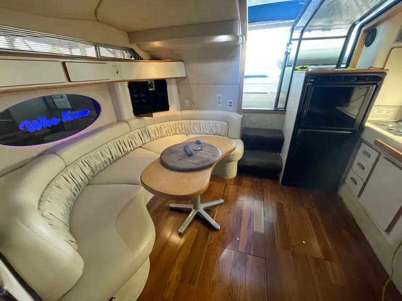 Slide: The Image of 1993 Sea Ray 400 Express Cruiser interior with curved seating and wooden flooring. - 18