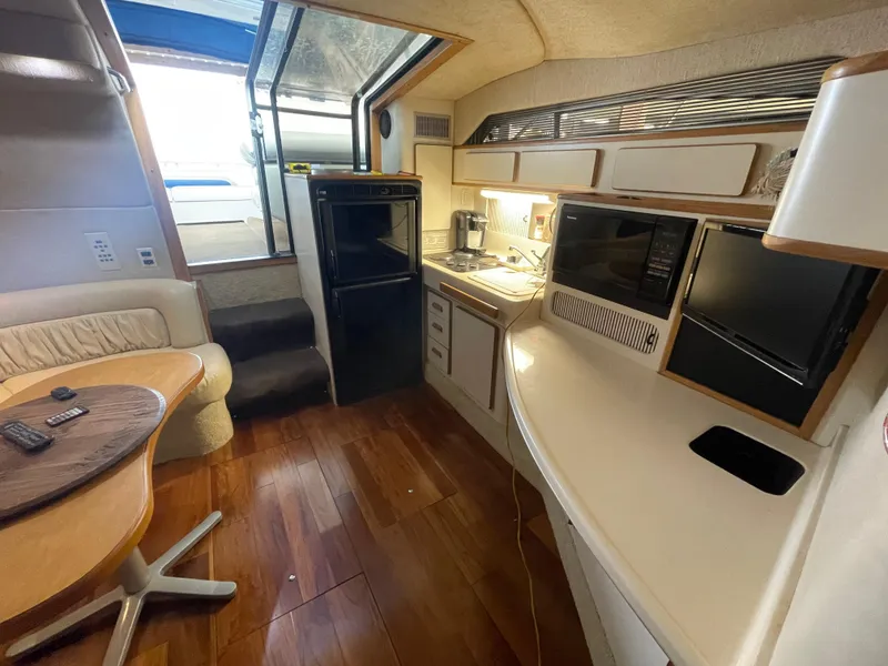 Slide: The Image of 1993 Sea Ray 400 Express Cruiser interior with kitchen and dining area. - 19