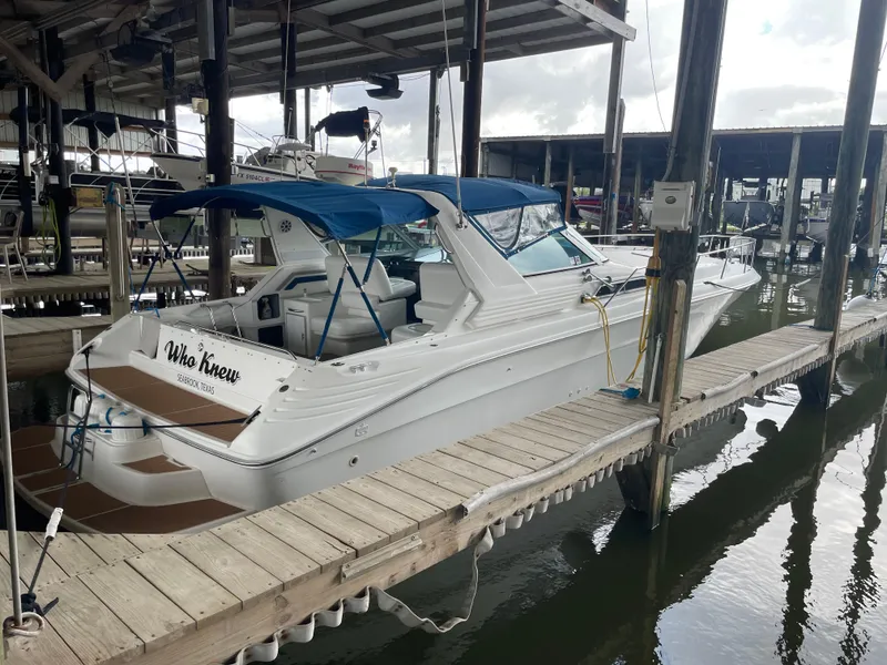 Slide: The Image of 1993 Sea Ray 400 Express Cruiser docked at marina with blue canopy. - 2