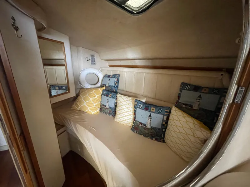 Slide: The Image of 1993 Sea Ray 400 Express Cruiser cabin with cozy seating and nautical-themed pillows. - 20