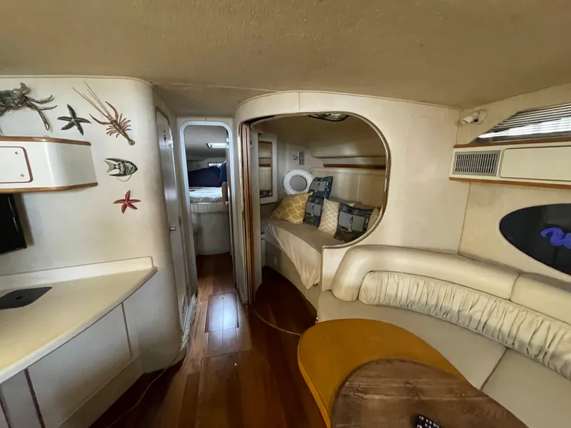 Slide: The Image of 1993 Sea Ray 400 Express Cruiser interior with cozy seating and nautical decor. - 22