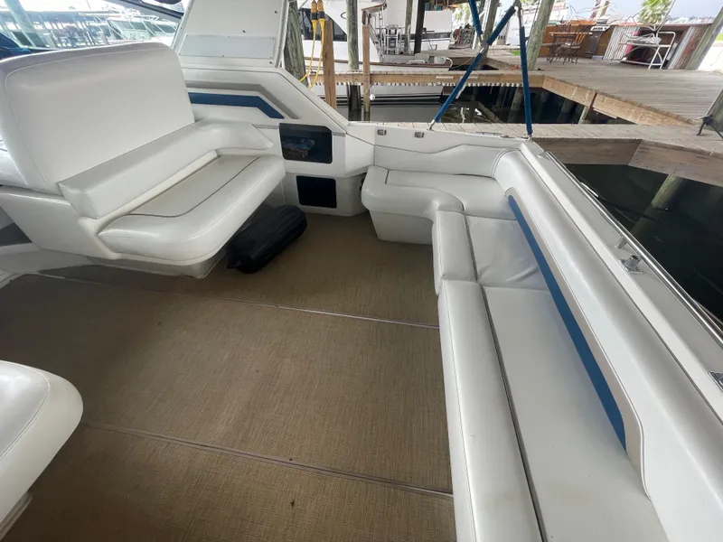 Slide: The Image of 1993 Sea Ray 400 Express Cruiser interior with white seating and beige flooring. - 6