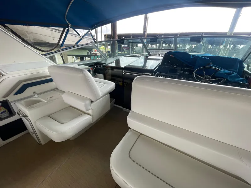 Slide: The Image of 1993 Sea Ray 400 Express Cruiser cockpit with white seating and blue canopy. - 8