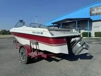 Slide: The Image of 1996 Four Winns 190 Horizon boat on trailer, parked outside a blue building. - 18