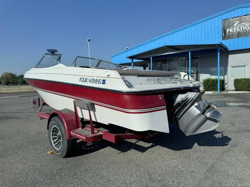 Slide: The Image of 1996 Four Winns 190 Horizon boat on a red trailer outside a dealership. - 6
