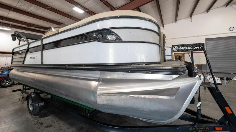 The Image of 2021 Crest Classic Platinum 220 SLSC pontoon boat in indoor storage. - 1