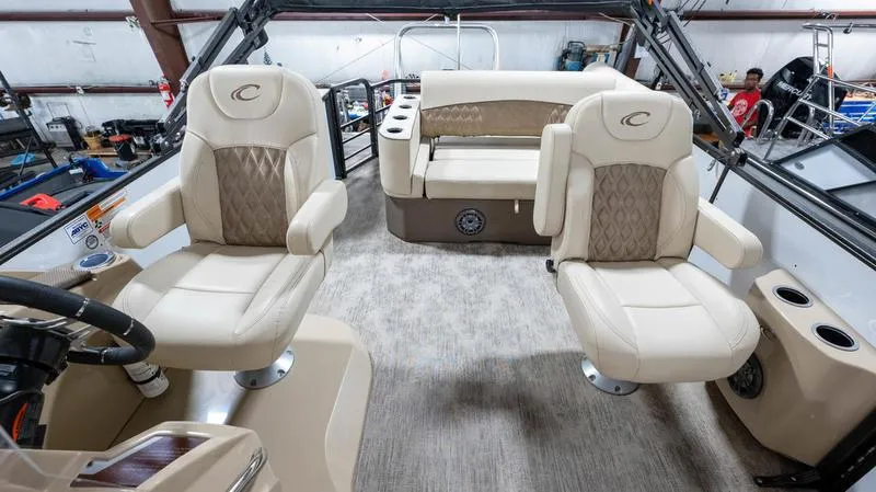 Slide: The Image of 2021 Crest Classic Platinum 220 SLSC boat interior with beige seating and helm. - 15