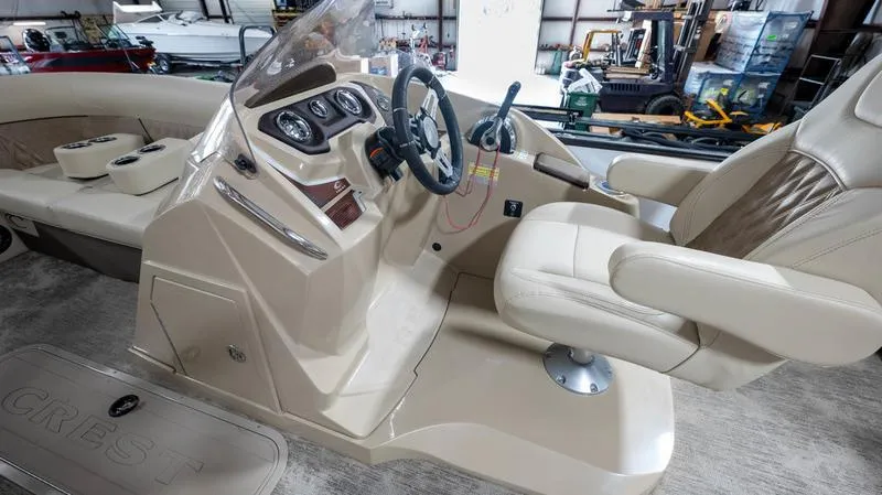 Slide: The Image of 2021 Crest Classic Platinum 220 SLSC boat interior with beige captain's chair and control console. - 16