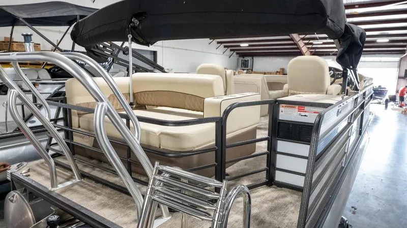 Slide: The Image of 2021 Crest Classic Platinum 220 SLSC pontoon boat with beige seating in a warehouse. - 30