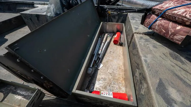 Slide: The Image of Open storage compartment in a 2003 War Eagle 754 LDSV boat with tools and fire extinguisher. - 17