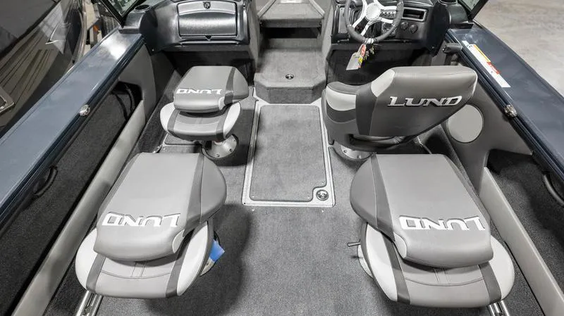 Slide: The Image of 2024 Lund 1875 Crossover XS boat interior with gray seating and steering console. - 10