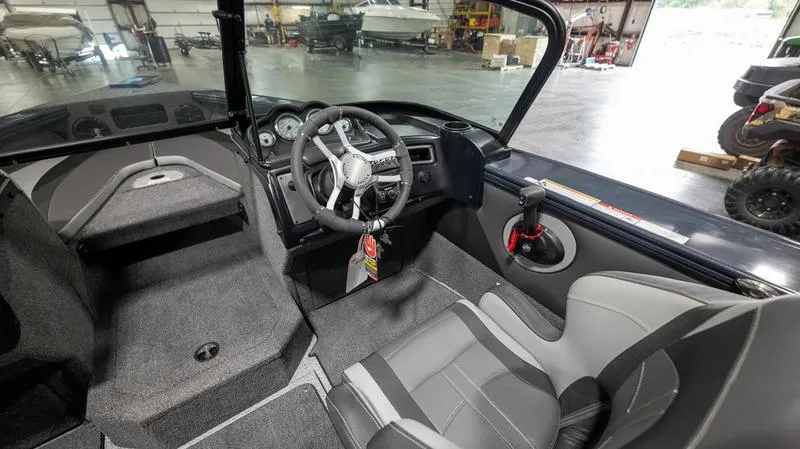 Slide: The Image of 2024 Lund 1875 Crossover XS boat interior with steering wheel and seating. - 11