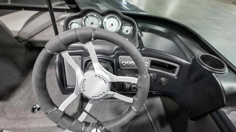 Slide: The Image of 2024 Lund 1875 Crossover XS boat dashboard with steering wheel and gauges. - 15