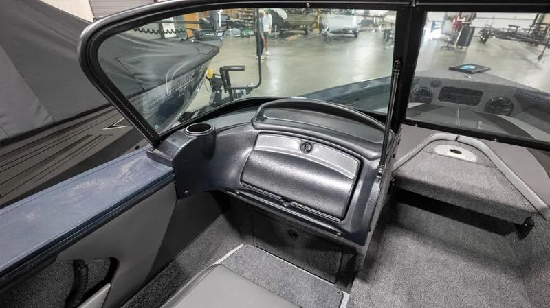 Slide: The Image of 2024 Lund 1875 Crossover XS boat interior with windshield and storage compartment. - 16
