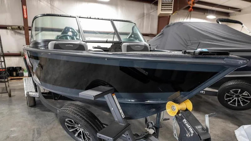 Slide: The Image of 2024 Lund 1875 Crossover XS boat in showroom, black exterior, on trailer. - 3