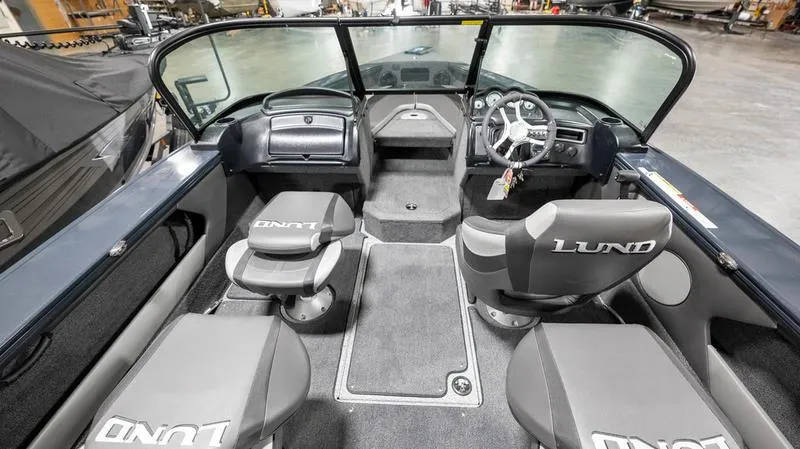 Slide: The Image of 2024 Lund 1875 Crossover XS boat interior with steering wheel and seating. - 4