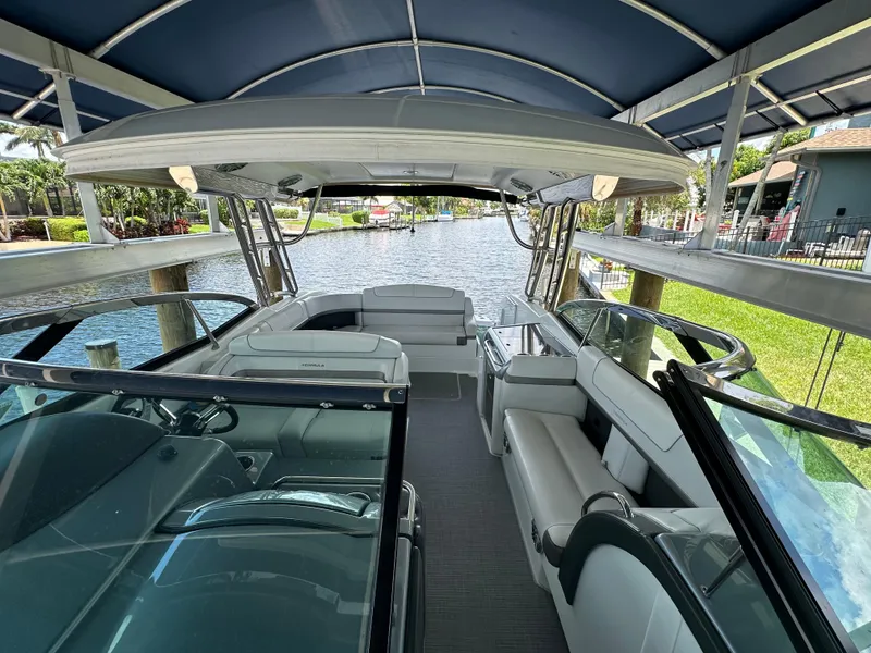 Slide: The Image of 2015 Formula 350 CBR boat interior with seating and canopy, docked by a canal. - 15