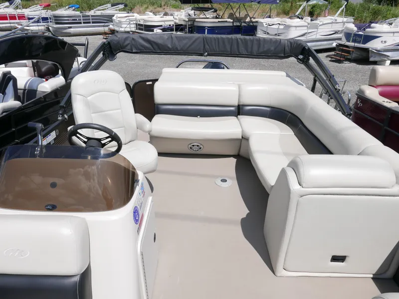 Slide: The Image of 2019 Manitou 23 Aroura VP pontoon boat interior with spacious seating and steering console. - 4
