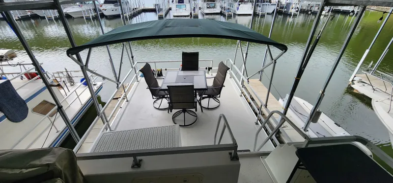Slide: The Image of 1993 Gibson 50 Cabin Yacht with covered outdoor seating area at marina. - 23