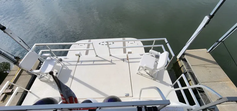 Slide: The Image of 1993 Gibson 50 Cabin Yacht deck with chairs and railing, docked by the water. - 24